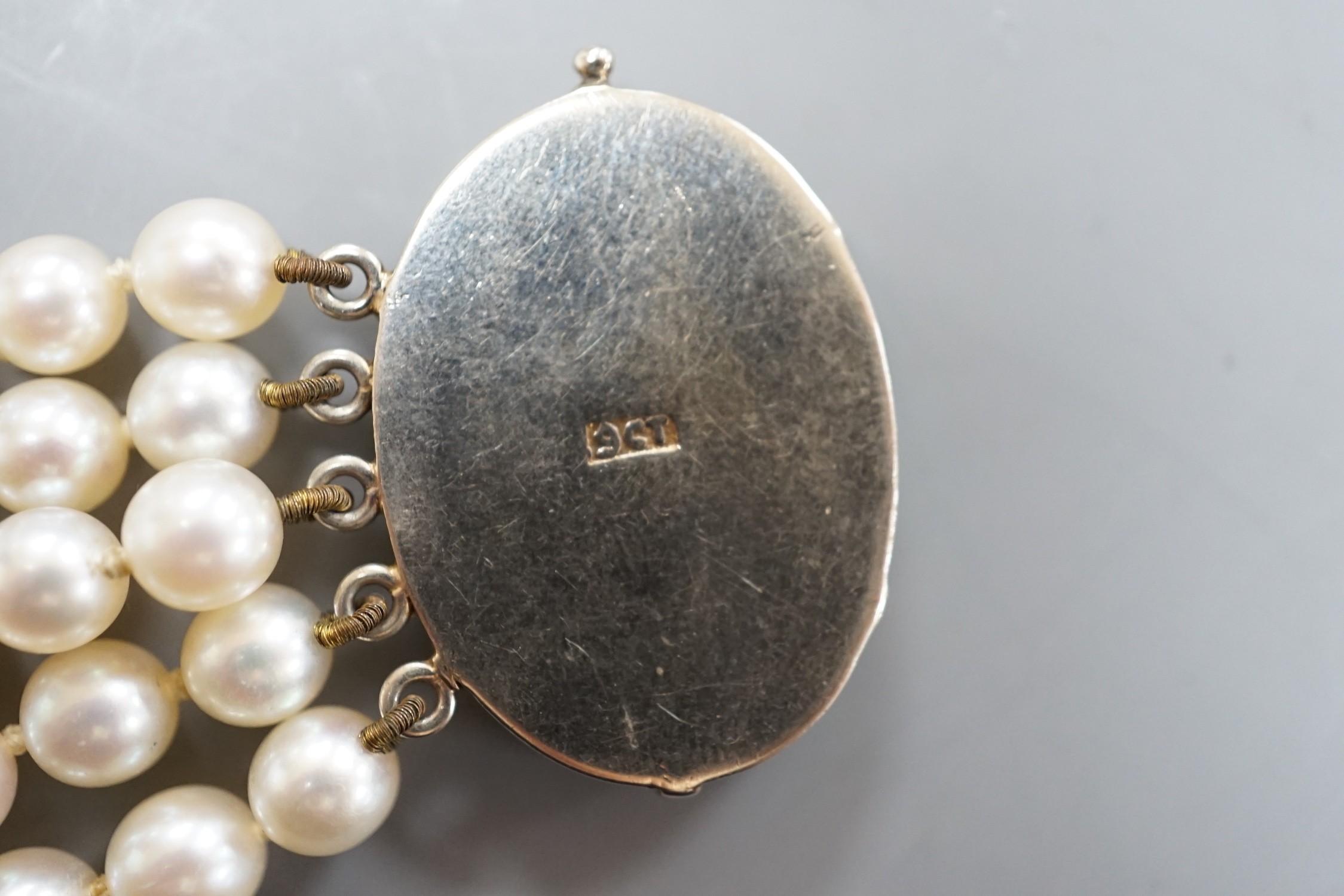 A quintuple strand cultured pearl bracelet, with carved jade set 9ct white metal clasp, 17cm, gross weight 42.5 grams, pearl diameter approx. 5.6mm.